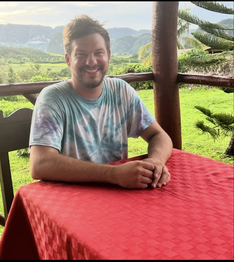 Forrest sitting at a table with a beautiful mountain valley view